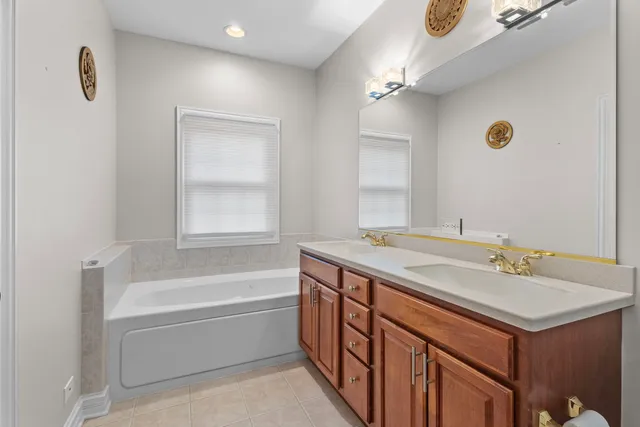 a bathroom with a tub sink and mirror
