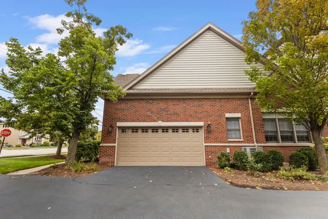 a front view of a house with a garden and garage