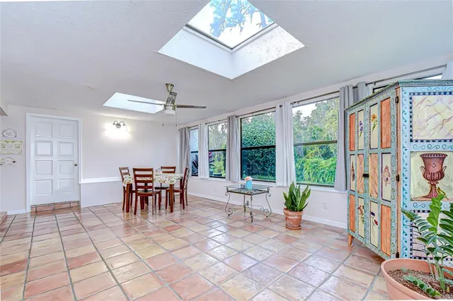 a dining room with furniture and a floor to ceiling window