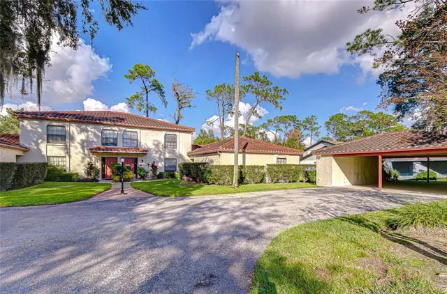 a view of a house with a yard and potted plants