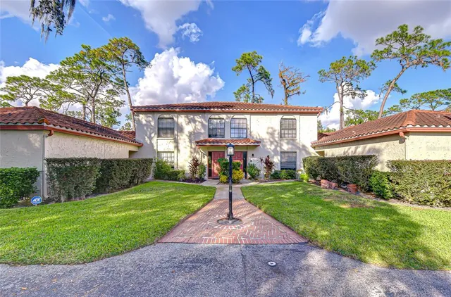 front view of a house with a yard and potted plants