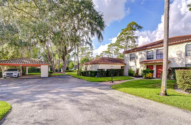 a view of a house with a yard and table and chairs under an umbrella