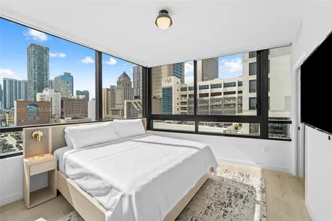 a bedroom with a large bed and a flat tv screen on dresser