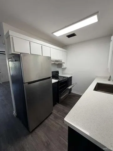 a kitchen with a refrigerator and a sink