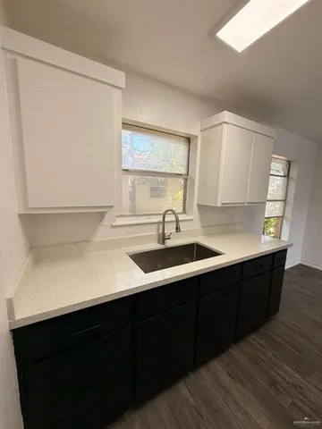 a kitchen with a sink cabinets and a window