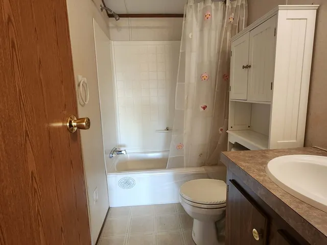 a bathroom with a granite countertop toilet sink and shower