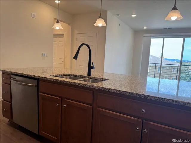 a kitchen with granite countertop cabinets a sink and dishwasher