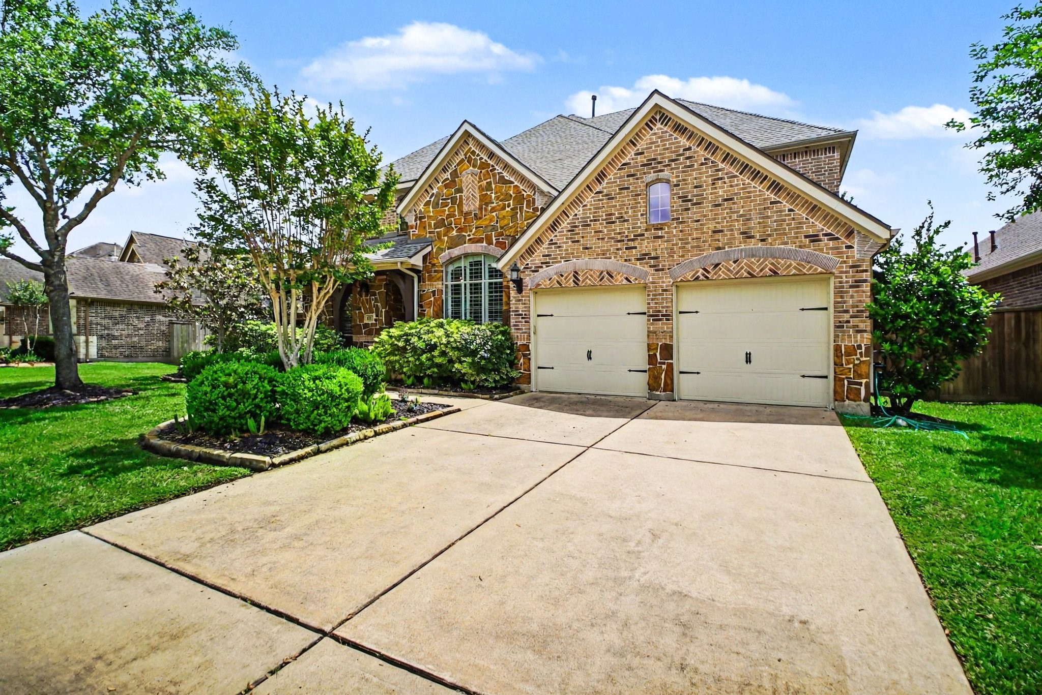 8210 Thunder Ridge Way Missouri City, TX 77459 - Photo 4 of 42 Spacious front view with a double-wide driveway leading to a large garage, featuring a tandem bay ideal for three vehicles.