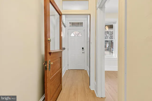 a view of a hallway with wooden floor and staircase