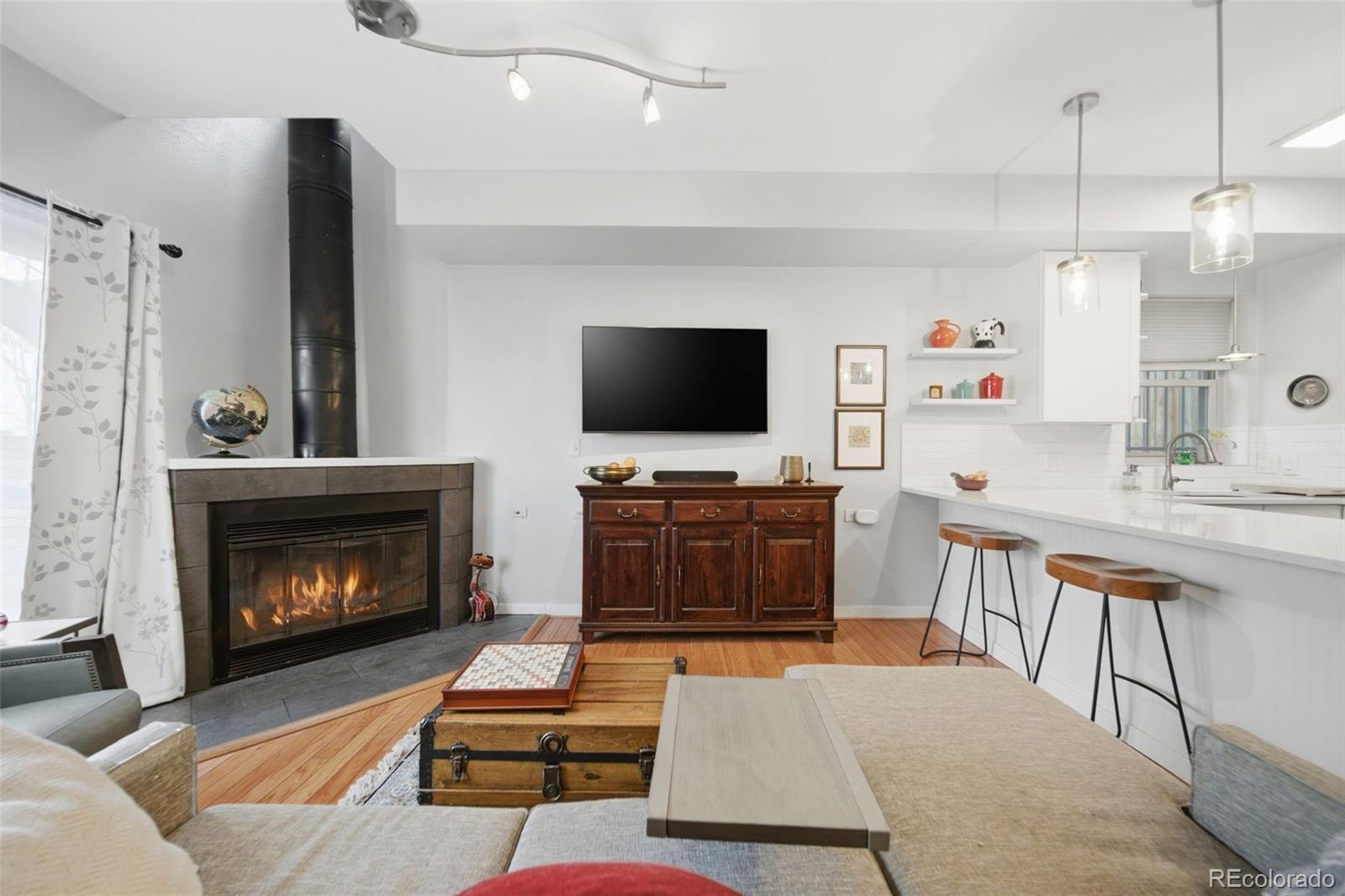 3045 Umatilla Street Denver, CO 80211 - Photo 4 of 48 a living room with furniture a fireplace and a flat screen tv