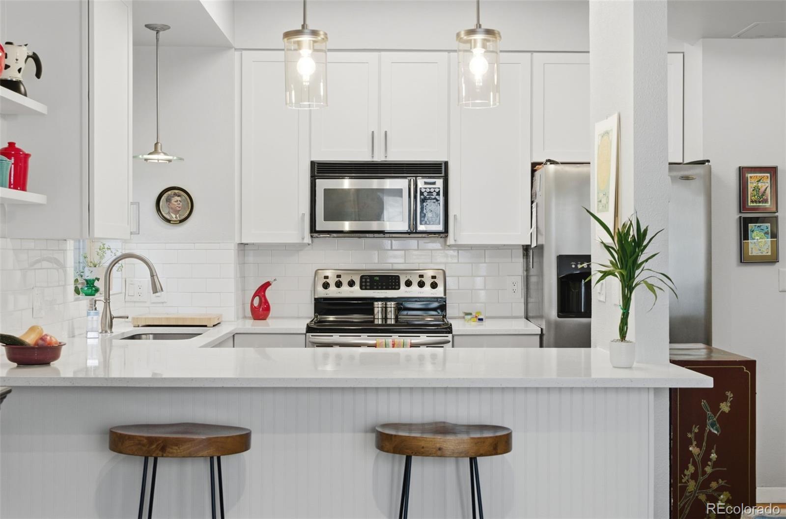 3045 Umatilla Street Denver, CO 80211 - Photo 10 of 48 a kitchen with stainless steel appliances a sink a refrigerator and a stove