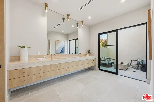 a spacious bathroom with a double vanity sink a mirror and a bathtub