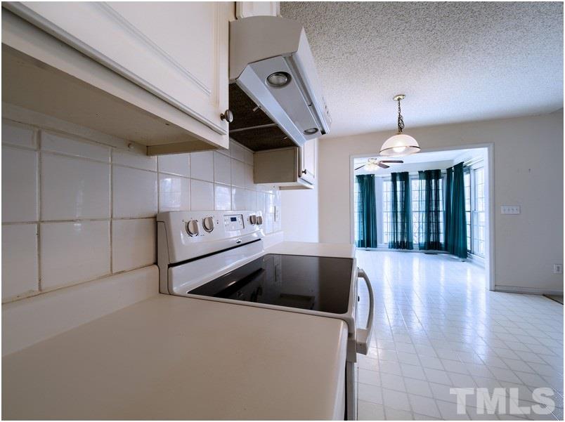 9513 Cub Trail Raleigh, NC 27615 - Photo 6 of 8 a kitchen with granite countertop a stove and a chandelier