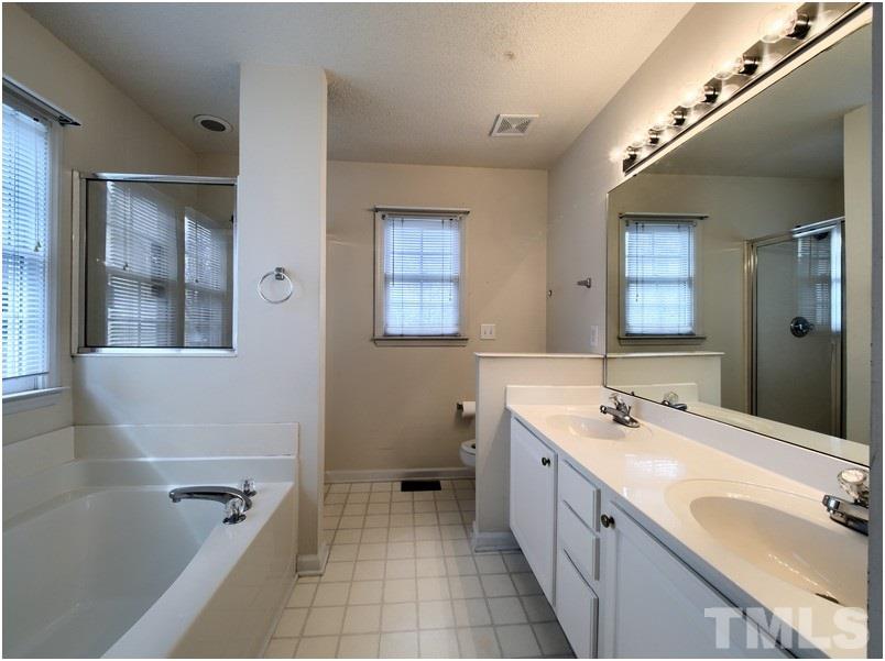 9513 Cub Trail Raleigh, NC 27615 - Photo 8 of 8 a bathroom with a granite countertop sink mirror bathtub and double