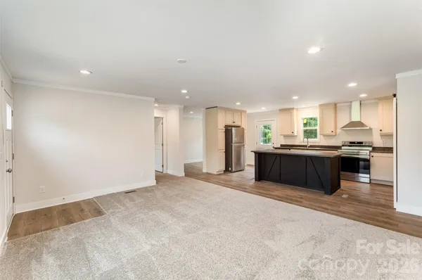 a large room with kitchen island a sink dishwasher a refrigerator and a counter top space