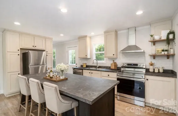 a kitchen with kitchen island granite countertop a sink stove and refrigerator