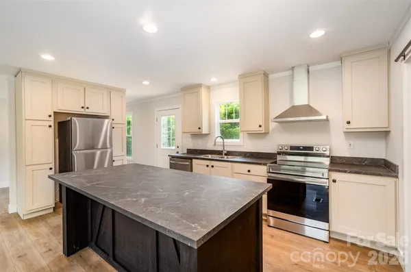 a kitchen with stainless steel appliances granite countertop a stove a refrigerator a sink a stove and island