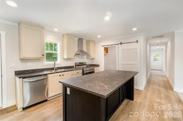 a kitchen with a stove a sink a refrigerator and a microwave