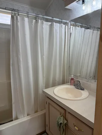 a living room with patio furniture and a grill