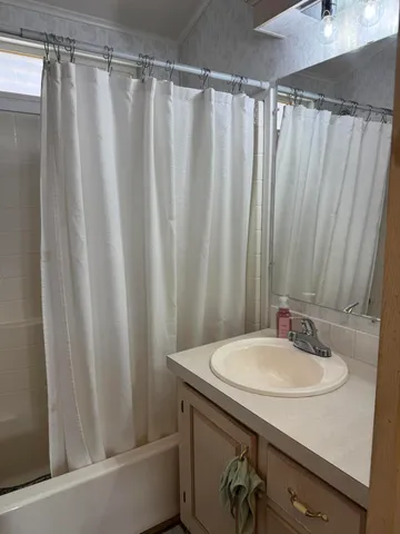 a living room with patio furniture and a grill