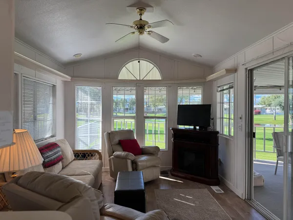 a living room with furniture a flat screen tv and kitchen view