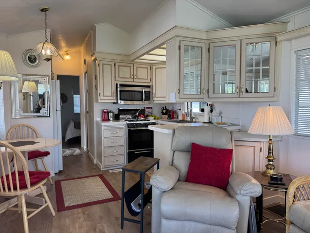 a kitchen with white cabinets and black appliances