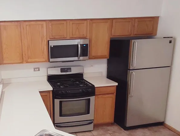 a kitchen with granite countertop a refrigerator stove and microwave