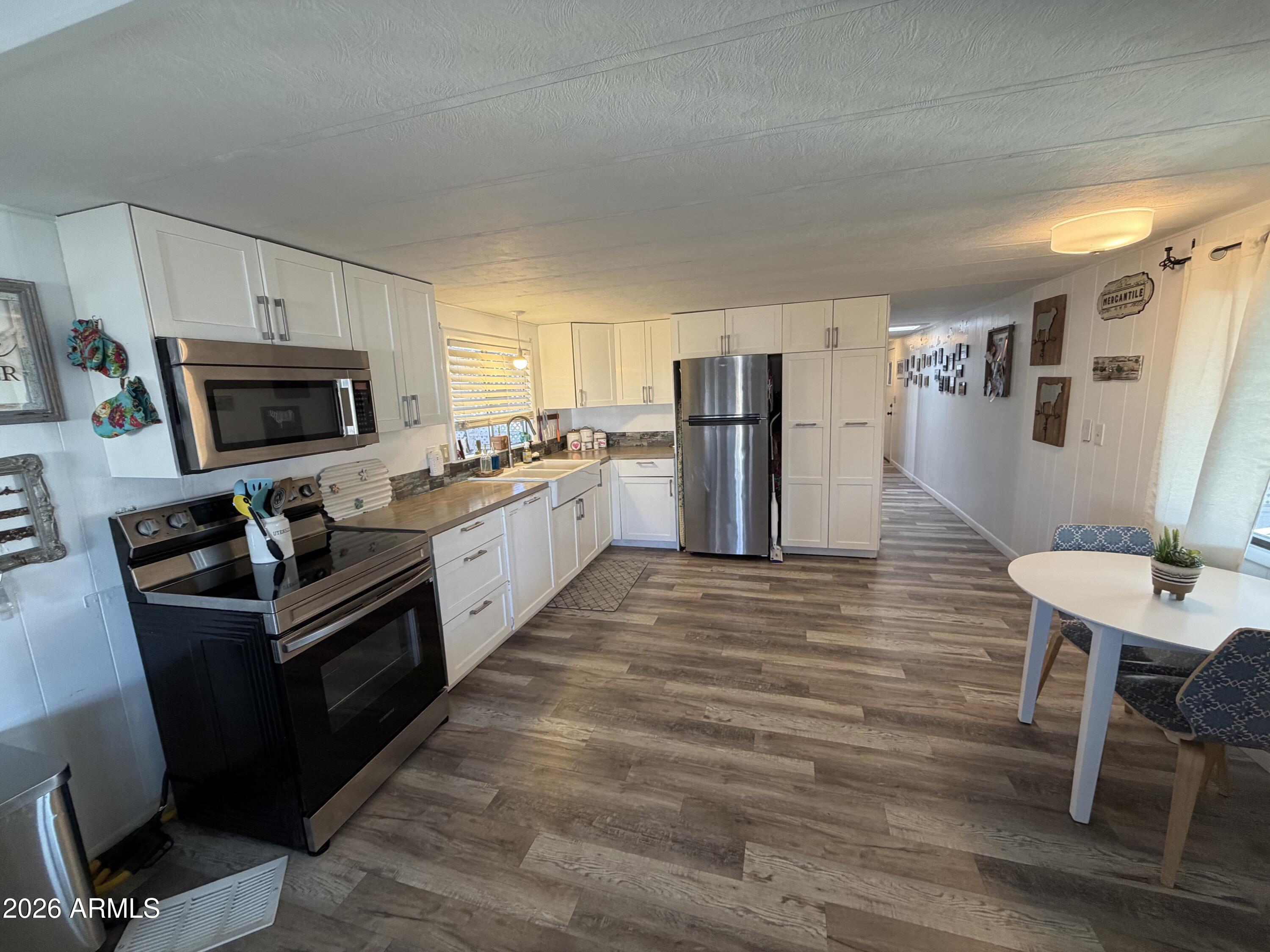 3104 East Broadway Road North, Unit 307 Mesa, AZ 85204 - Photo 7 of 11 a kitchen with a refrigerator a stove top oven a sink and dishwasher