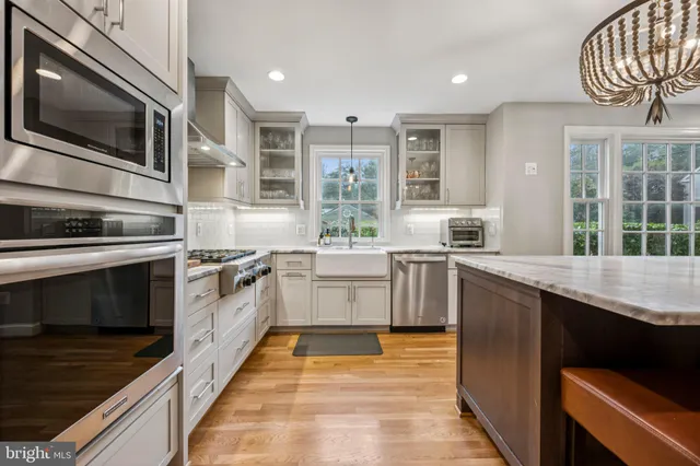 a kitchen with stainless steel appliances kitchen island granite countertop a stove a sink and a microwave
