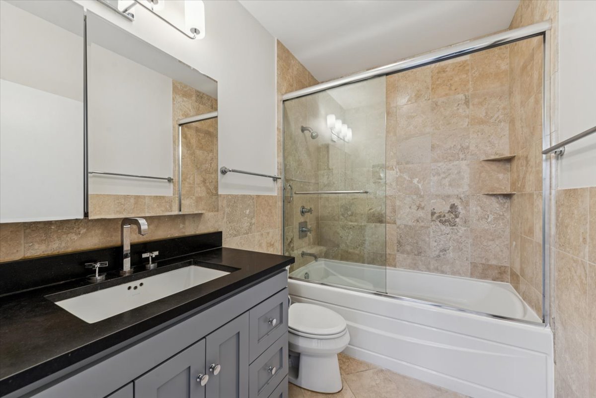 2225 West Madison Street, Unit 7 Chicago, IL 60612 - Photo 16 of 32 a bathroom with a granite countertop sink a toilet and bathtub
