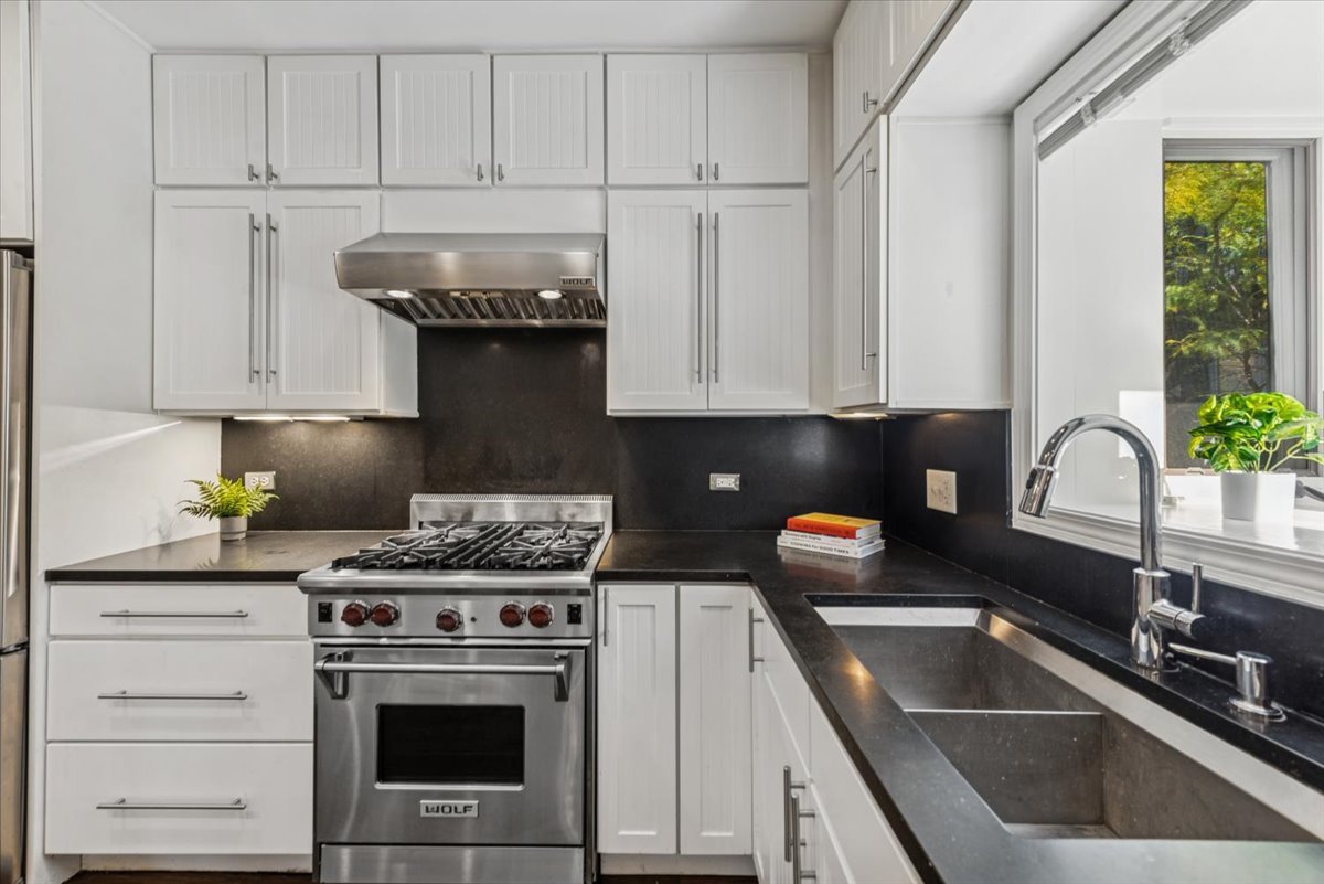 2225 West Madison Street, Unit 7 Chicago, IL 60612 - Photo 7 of 32 a kitchen with granite countertop a sink stainless steel appliances and cabinets