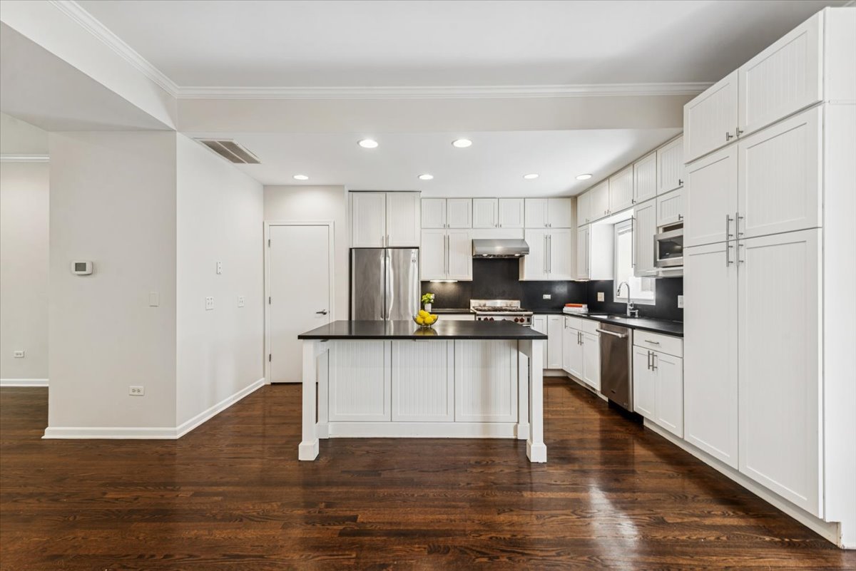 2225 West Madison Street, Unit 7 Chicago, IL 60612 - Photo 9 of 32 a kitchen with a refrigerator and a stove top oven
