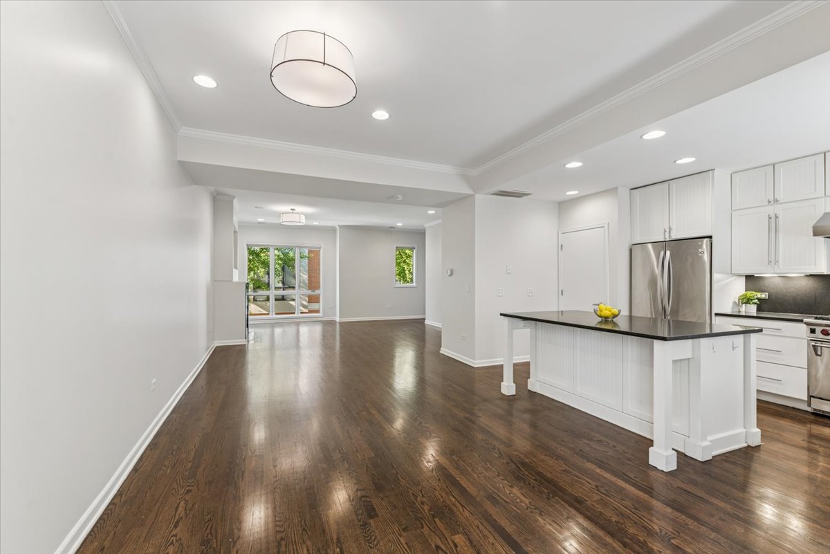 2225 West Madison Street, Unit 7 Chicago, IL 60612 - Photo 10 of 32 a open kitchen with stainless steel appliances granite countertop a stove a sink a refrigerator and white cabinets with wooden floor