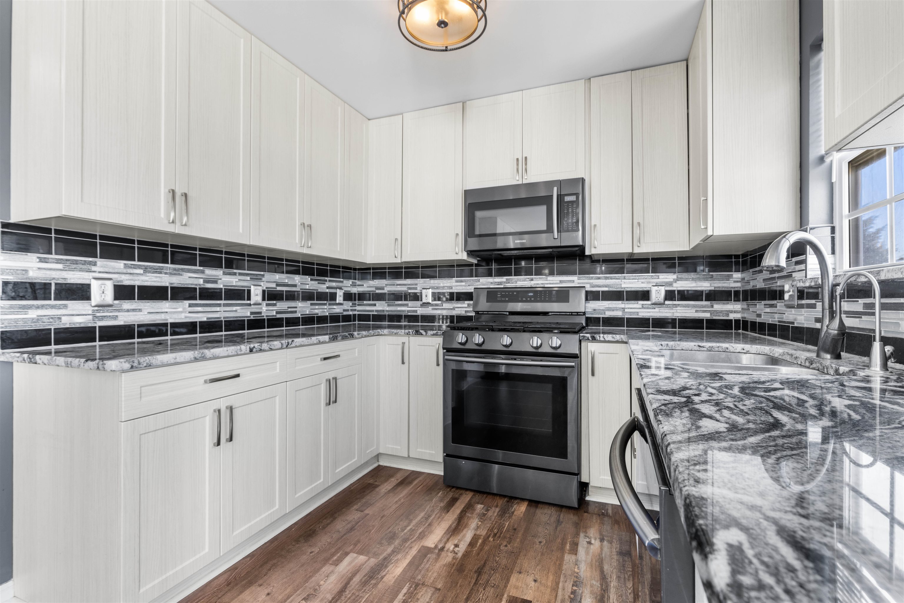 9360 Corriedale Run Roscoe, IL 61073 - Photo 5 of 34 a kitchen with stainless steel appliances granite countertop a stove a sink and a microwave