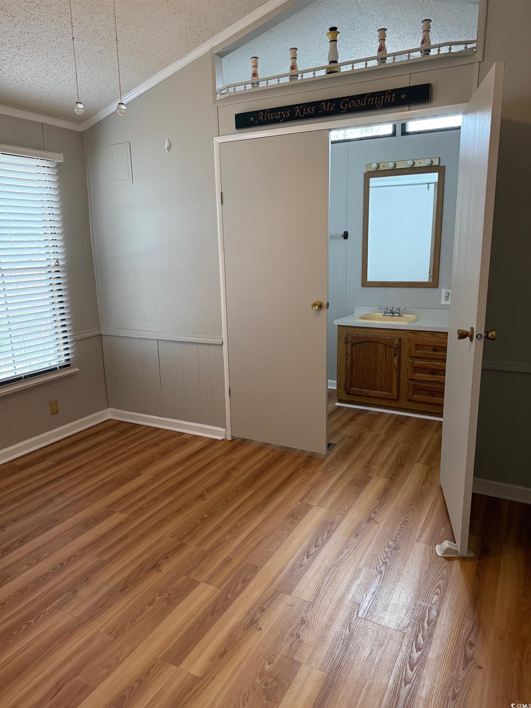 159 Crooked Island Circle Murrells Inlet, SC 29576 - Photo 14 of 20 Unfurnished bedroom with light wood finished floors, ornamental molding, a textured ceiling, and wainscoting