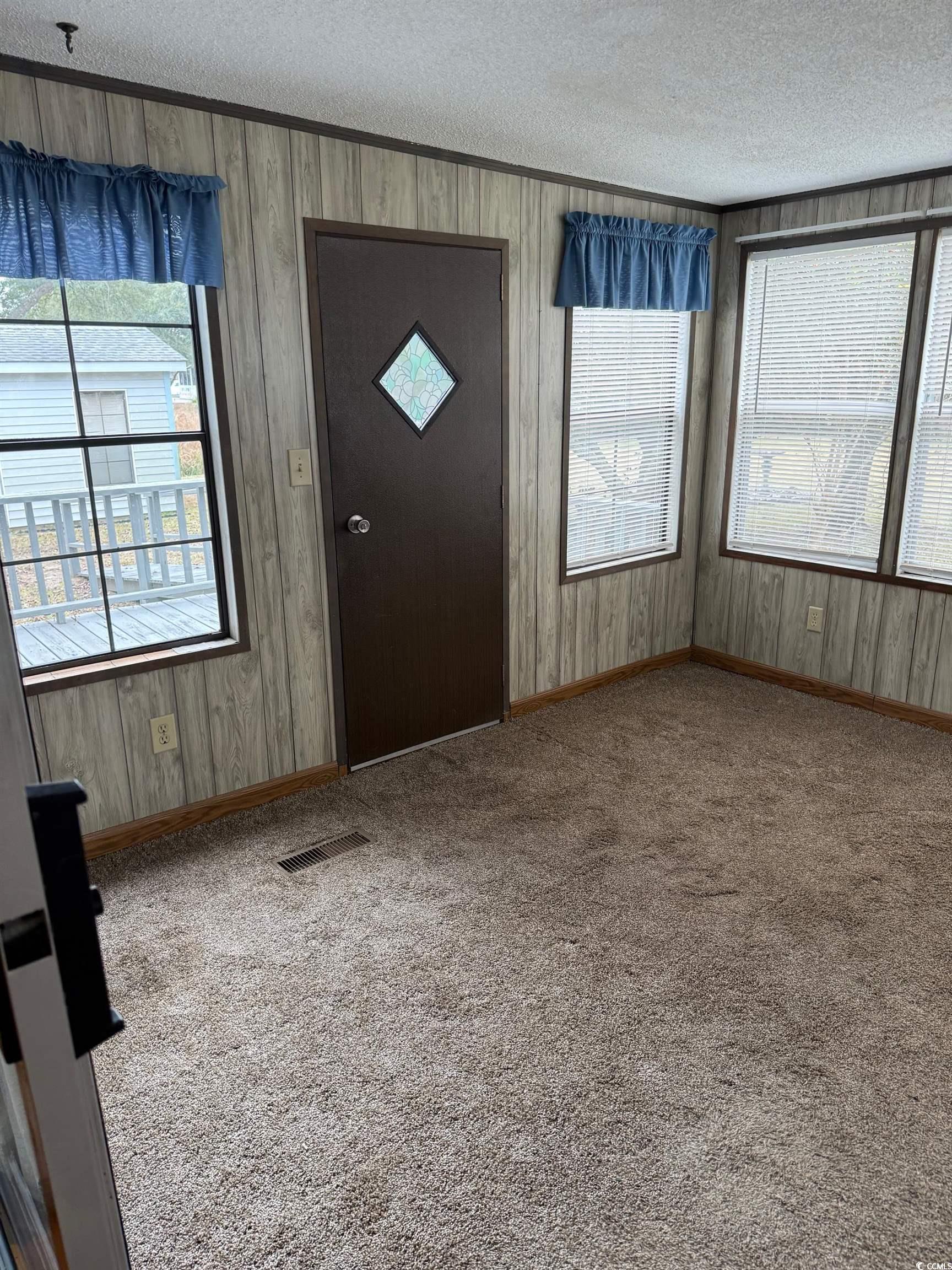 159 Crooked Island Circle Murrells Inlet, SC 29576 - Photo 20 of 20 Carpeted entrance foyer with a textured ceiling and wooden walls