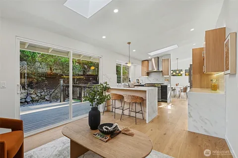 a dining room with wooden floor a chandelier a wooden table and chairs