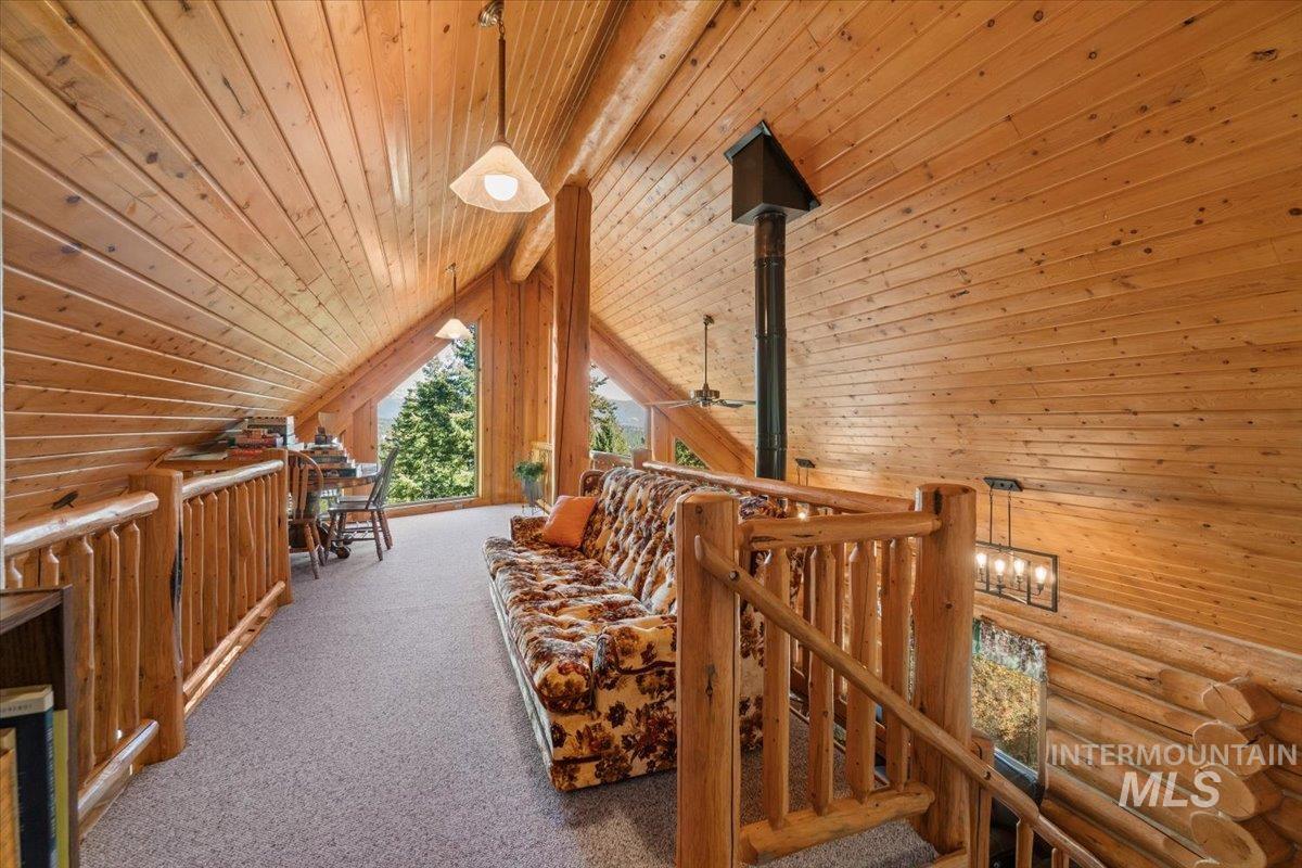 3725 Rim Road New Meadows, ID 83654 - Photo 24 of 50 Corridor featuring wood ceiling, an upstairs landing, wooden walls, and carpet flooring