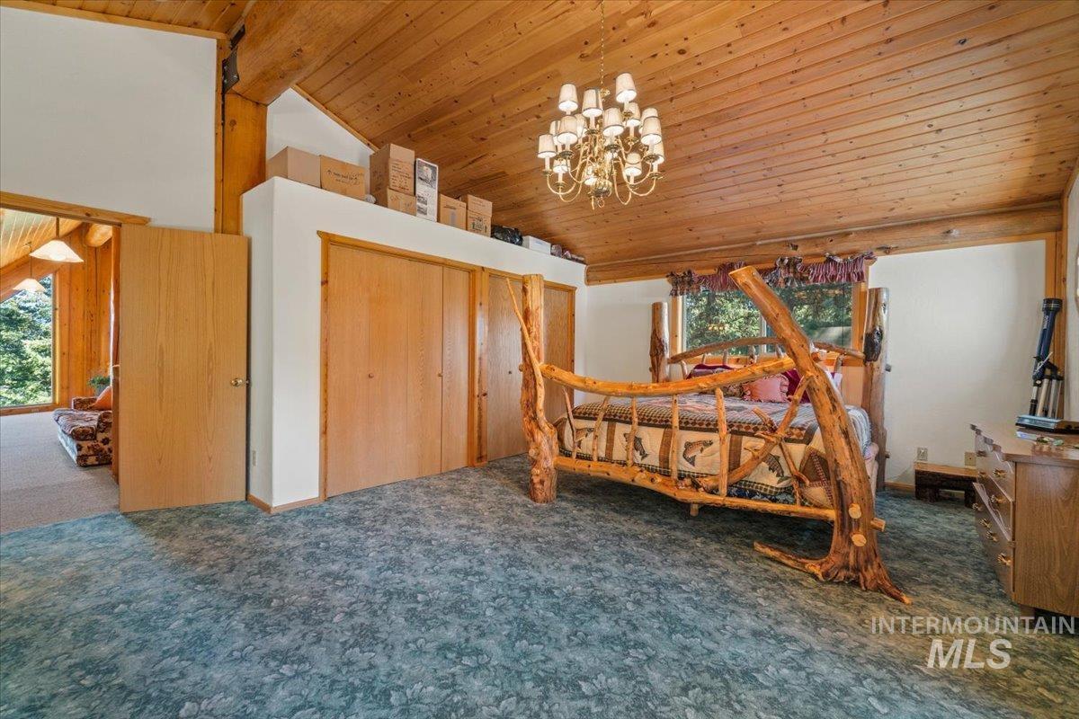 3725 Rim Road New Meadows, ID 83654 - Photo 28 of 50 Bedroom with carpet flooring, high vaulted ceiling, a chandelier, wood ceiling, and a closet