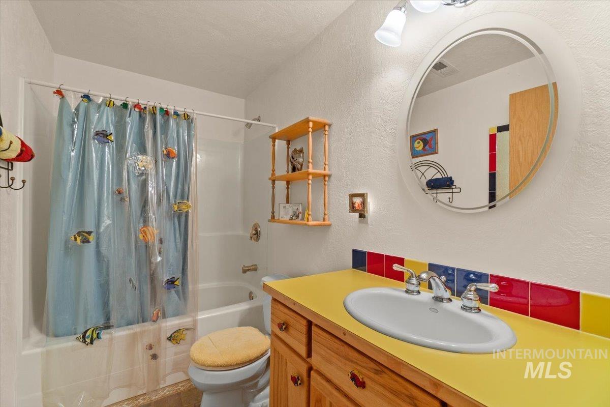 3725 Rim Road New Meadows, ID 83654 - Photo 39 of 50 Full bath with shower / bathtub combination with curtain, a textured wall, and vanity