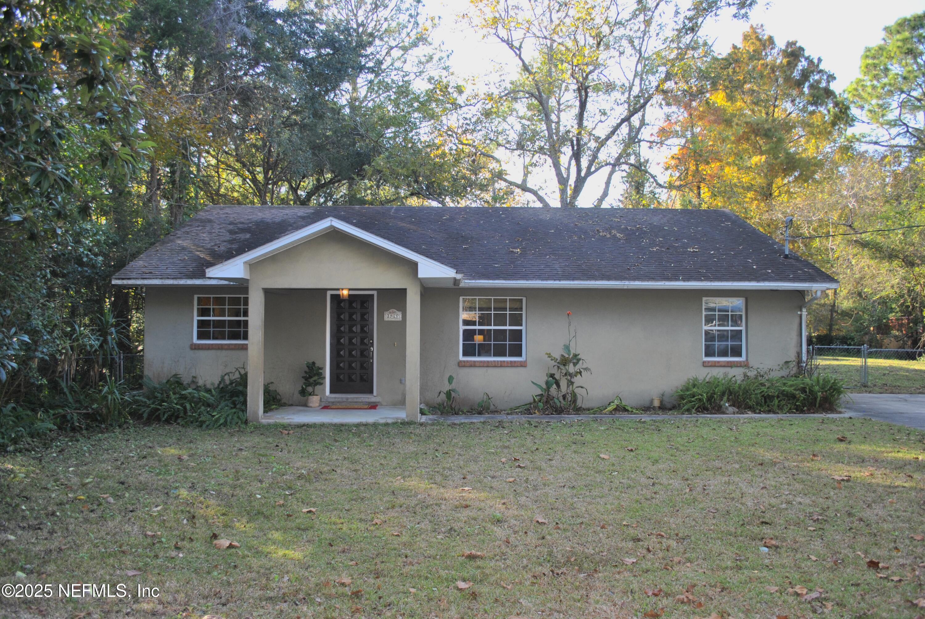 a front view of house with yard and trees