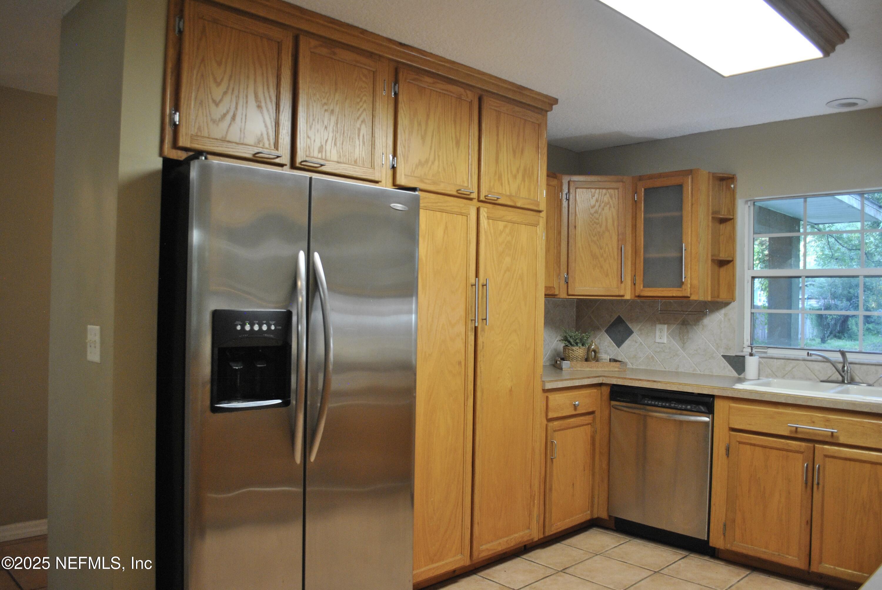 2819 North 6th Street St. Augustine, FL 32084 - Photo 11 of 18 a kitchen with a refrigerator and cabinets