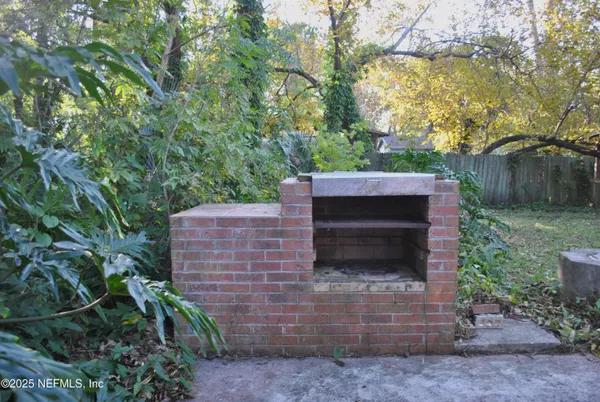 a view of a chair and table in backyard of the house
