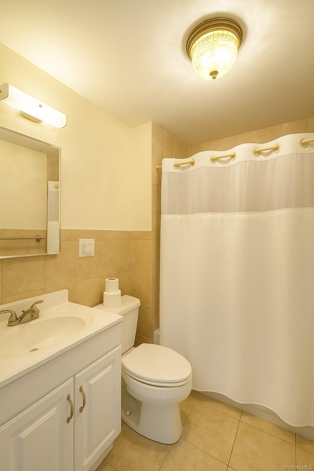104 Livingston Avenue, Unit 2 Yonkers, NY 10705 - Photo 6 of 12 a bathroom with a toilet a sink and mirror