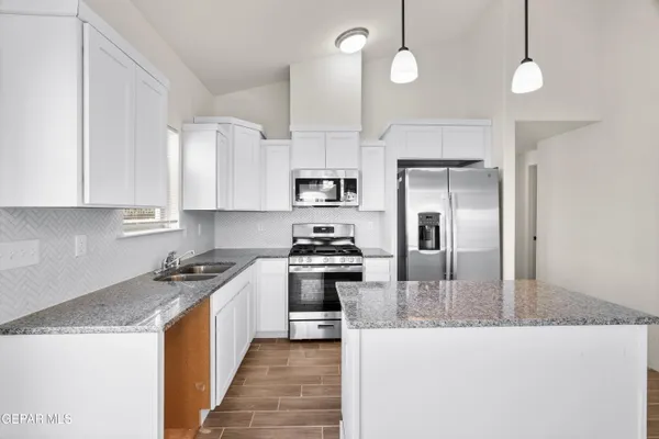 a view of a kitchen center island with wooden floor and staircase