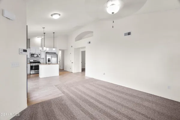 an empty room with windows and ceiling fan