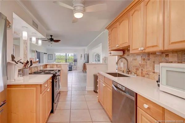 a kitchen with stainless steel appliances granite countertop a sink stove and cabinets
