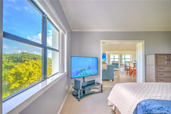 a bedroom with furniture and a large window