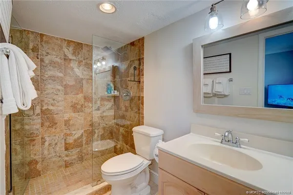 a bathroom with a sink a toilet and shower