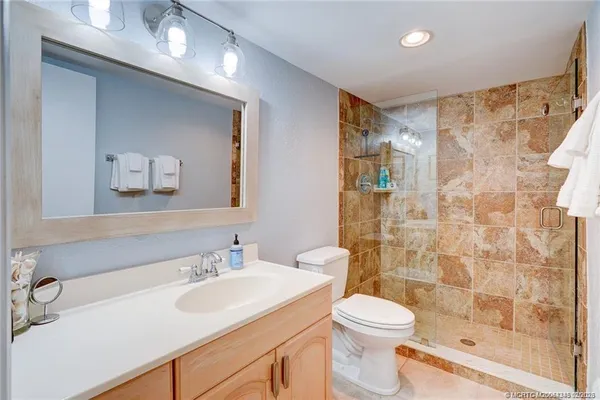 a bathroom with a sink a toilet and shower